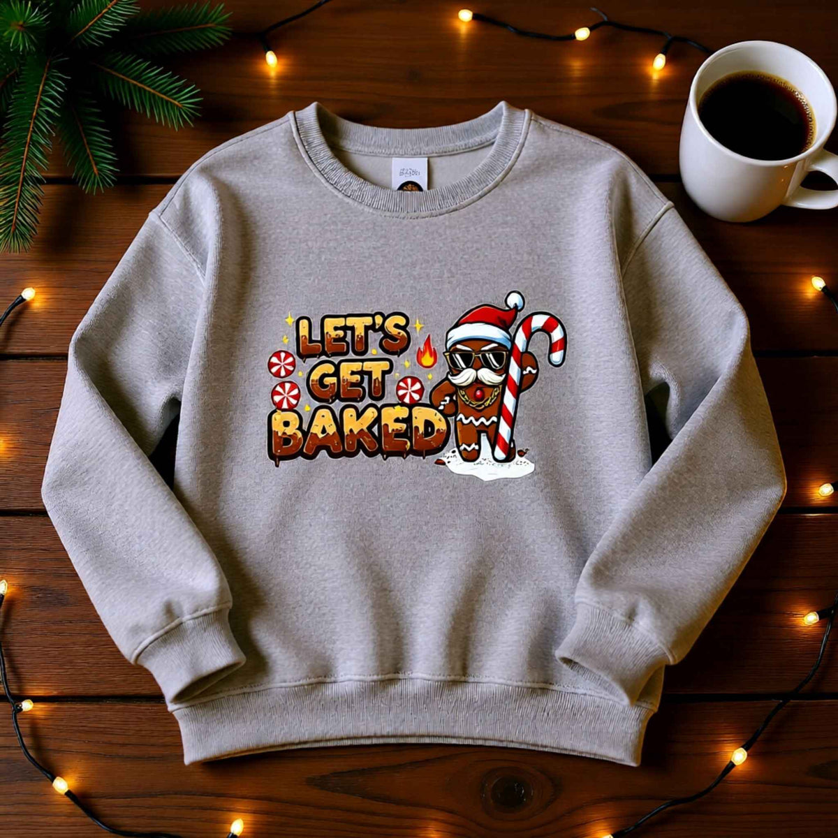 Flat lay of ‘Let’s Get Baked’ gingerbread Christmas crewneck sweatshirt with festive holiday background