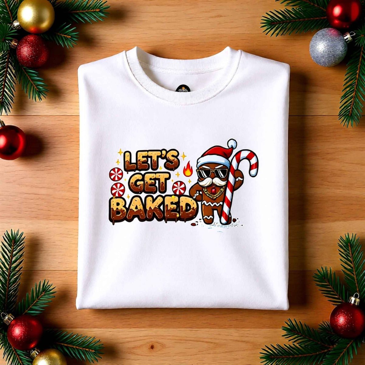 Flat lay of ‘Let’s Get Baked’ gingerbread Christmas crewneck sweatshirt with festive holiday background
