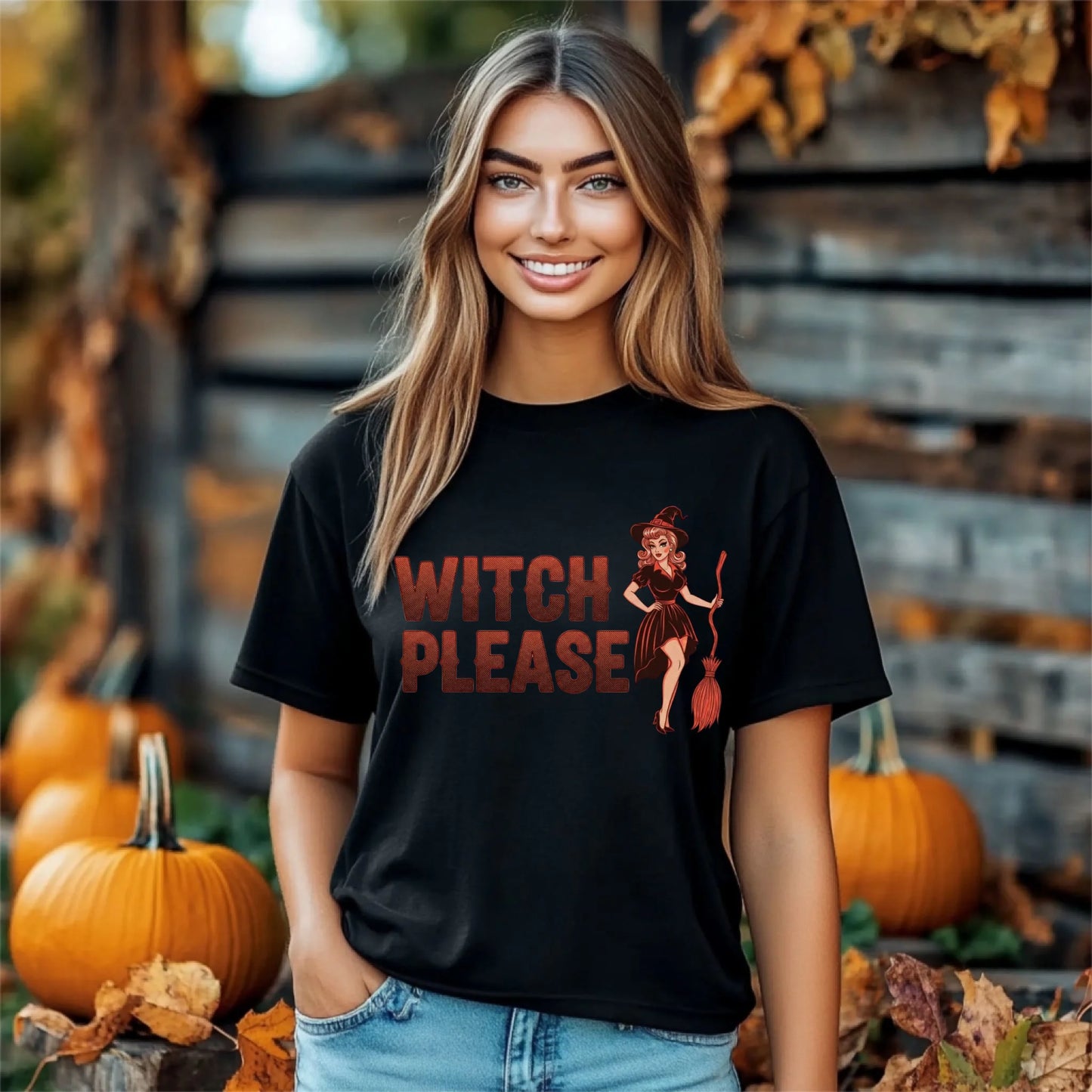 Woman wearing a black t-shirt with 'Witch Please' graphic in a Halloween setting with pumpkins and fall decorations.