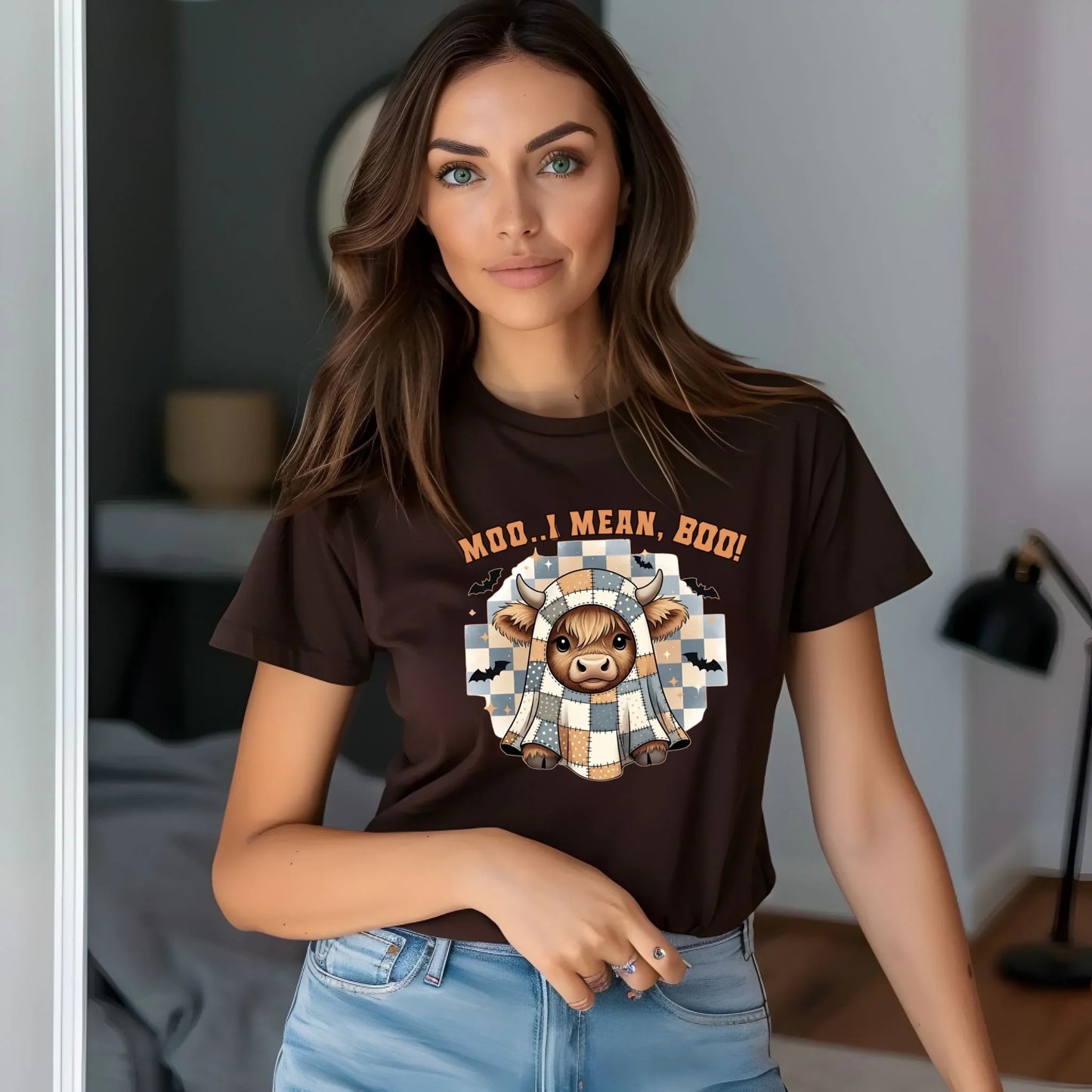 Woman wearing a brown t-shirt with a graphic design and text, standing in a room.