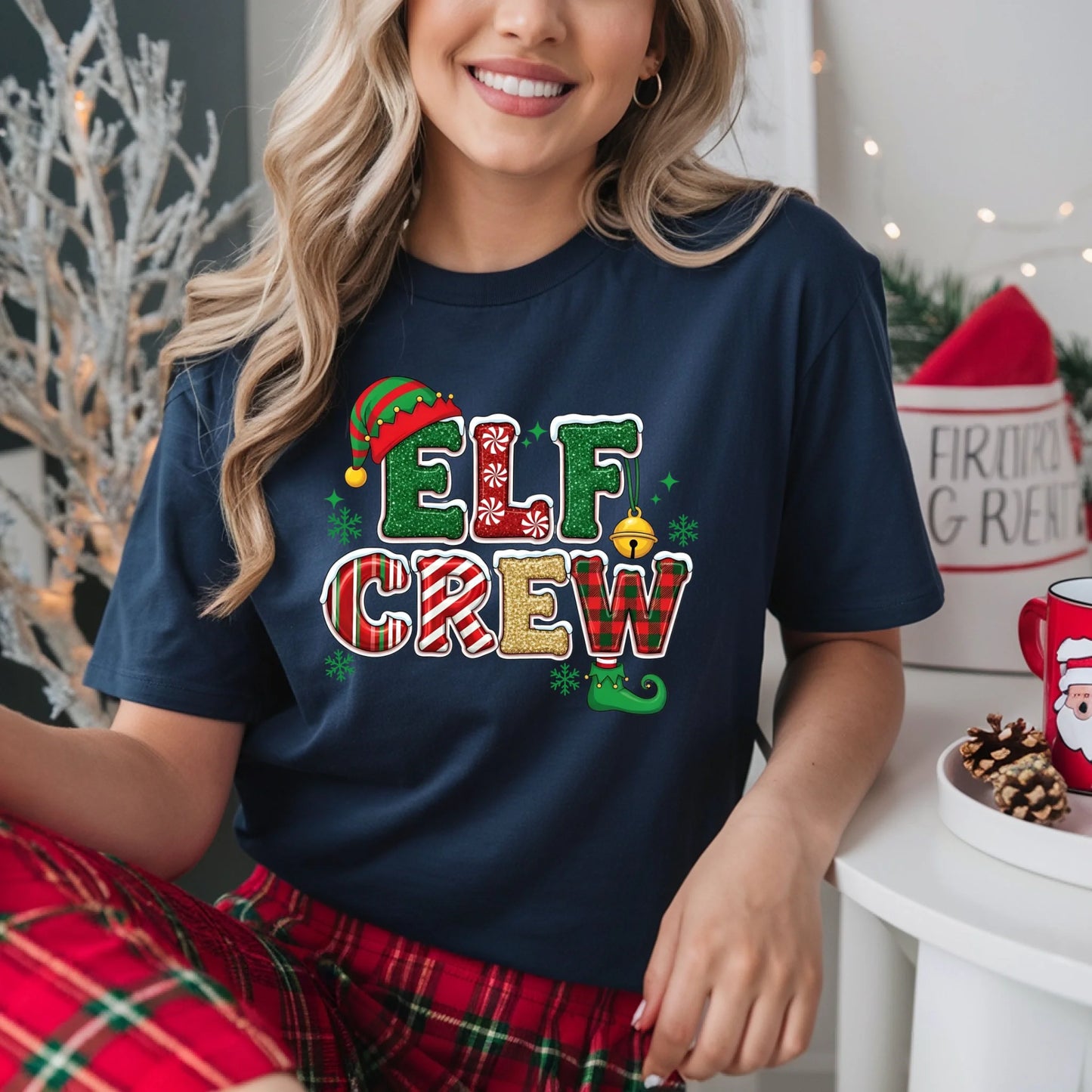 Person wearing a navy blue t-shirt with 'Elf Crew' print in a festive setting.