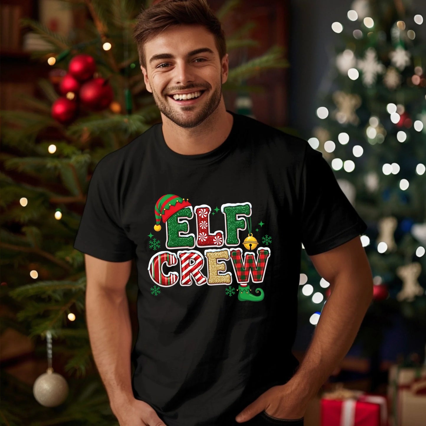 Man wearing a black t-shirt with 'Elf Crew' design in front of Christmas trees.