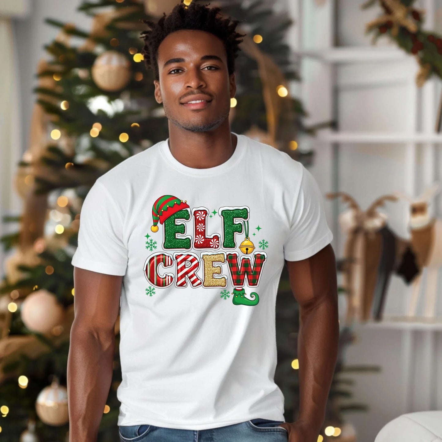 Man wearing a 'Elf Crew' t-shirt in front of a decorated Christmas tree.