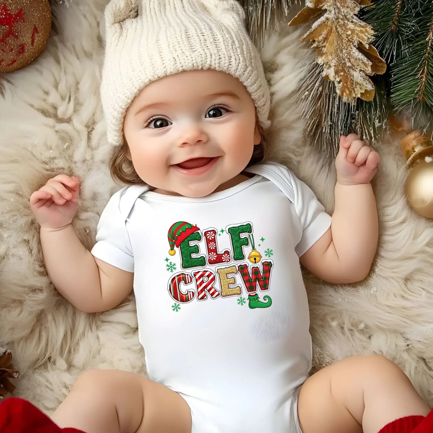 Baby wearing a 'Elf Crew' Christmas-themed onesie surrounded by holiday decorations.