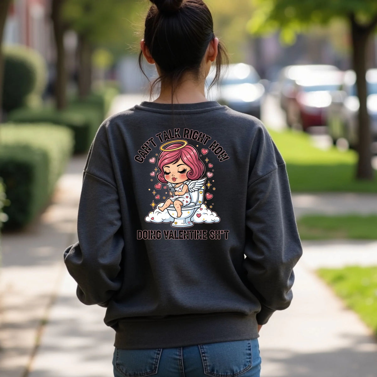Person wearing a dark heather crewneck sweatshirt with a graphic design on the back, featuring a humorous Toilet Cupid Valentine graphic.