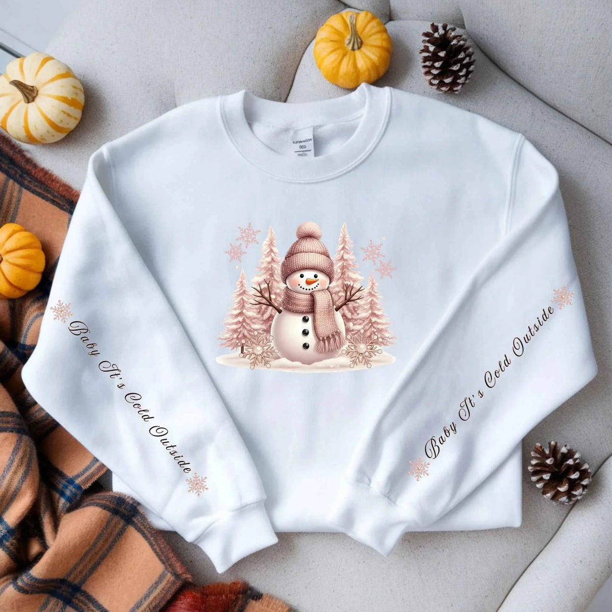 Flat lay of Snowman Winter Collection “Baby It’s Cold Outside” sleeve text design. Cozy Christmas Crewneck Sweatshirt
