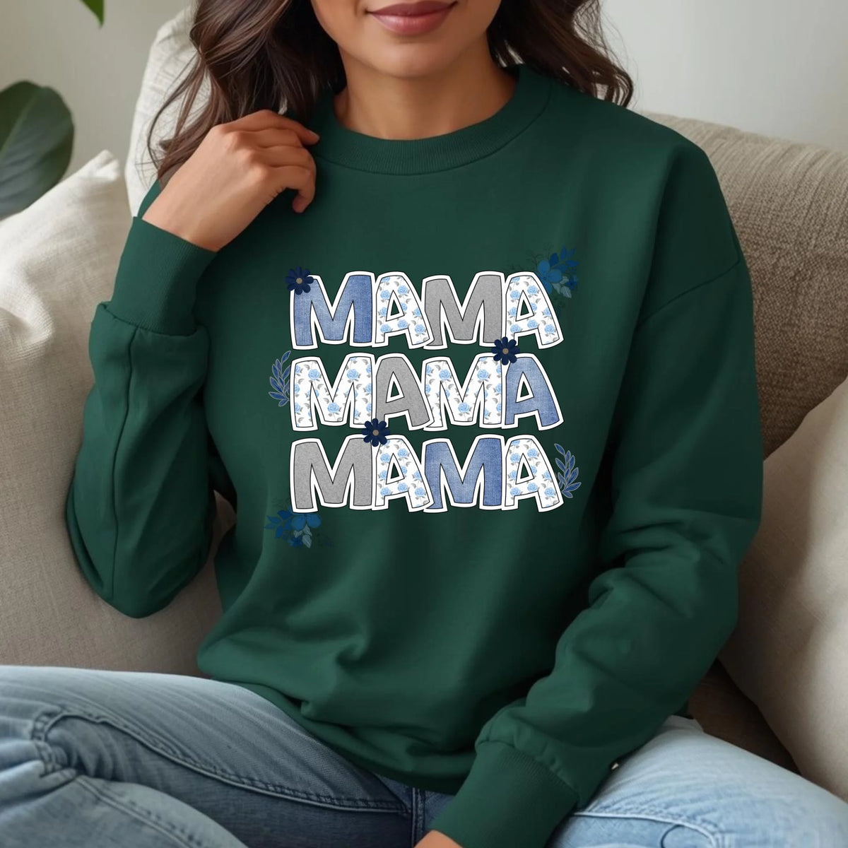 Woman wearing a green floral “Mama” crewneck sweatshirt styled indoors with a cozy, relaxed fit.