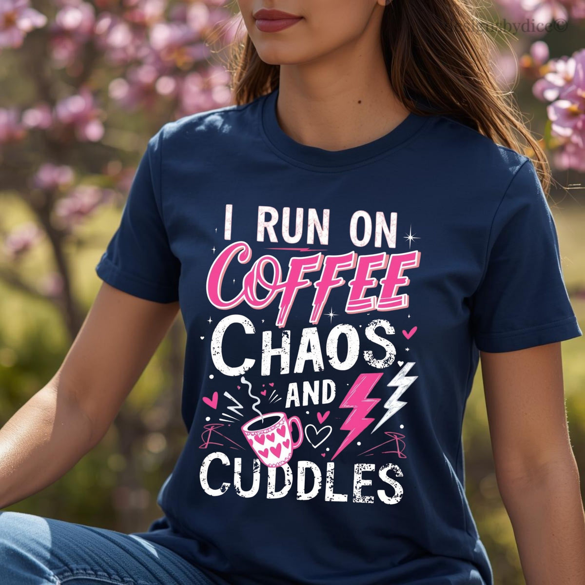 Person wearing a navy blue t-shirt with text 'I run on coffee, chaos, and cuddles' in an outdoor setting.