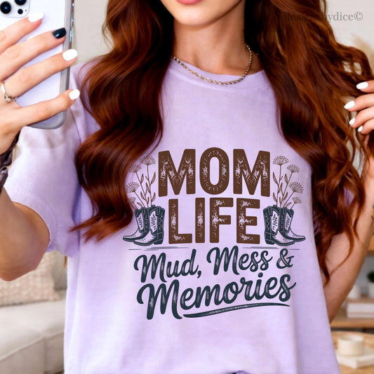 Woman wearing a white t-shirt with 'Mom Life: Mud, Mess & Memories' text and graphic.