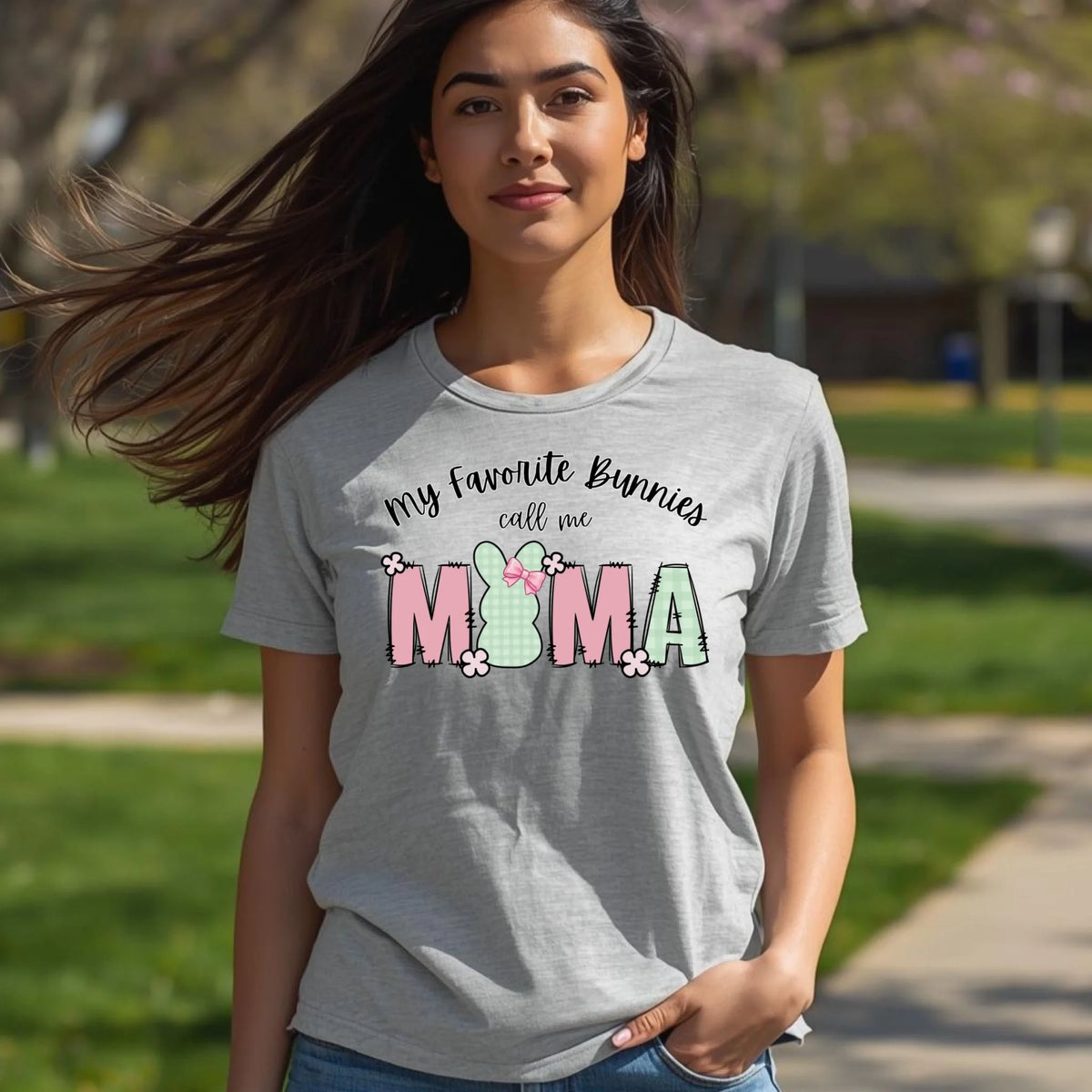 Model wearing a heather gray Bella Canvas t-shirt with an Easter bunny Mama graphic, photographed outdoors in natural daylight.
