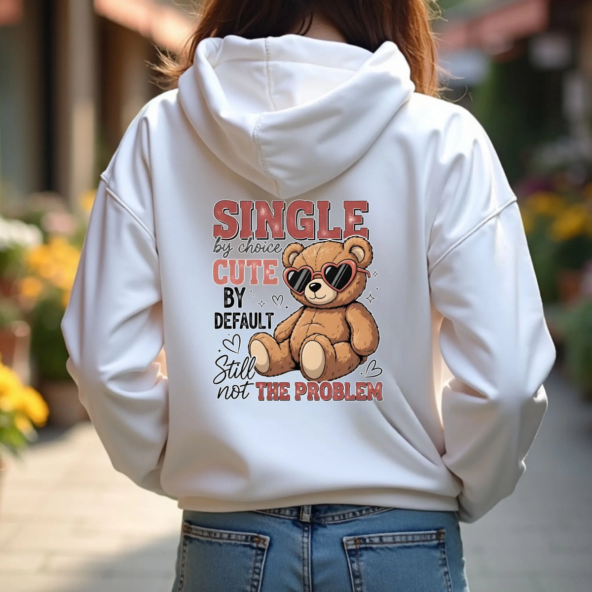 Person wearing a white hoodie with a teddy bear graphic and text on the back.