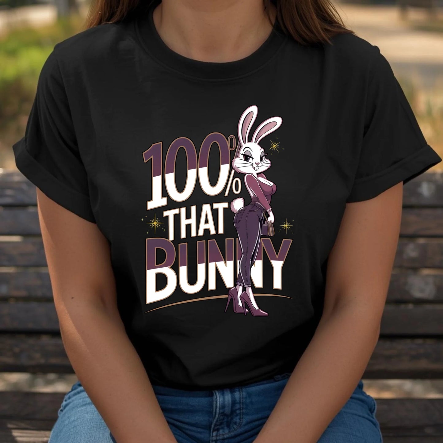 Woman seated casually wearing a black Bella + Canvas t-shirt featuring the 100% That Bunny Easter graphic. Relaxed lifestyle pose showcasing a confident, trendy bunny design perfect for spring outfits.