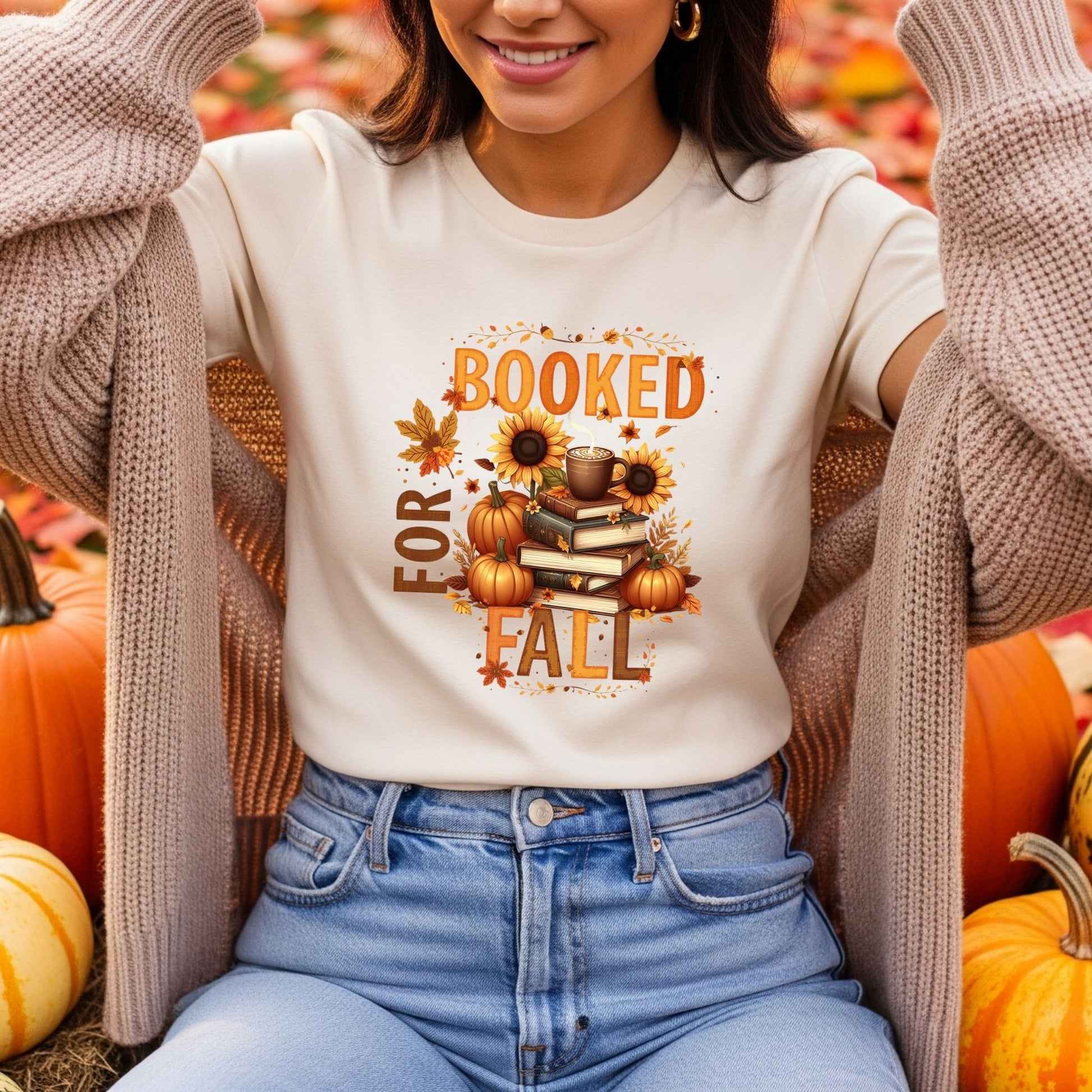 Person wearing a 'Booked for Fall' shirt with pumpkins and books design, surrounded by pumpkins.