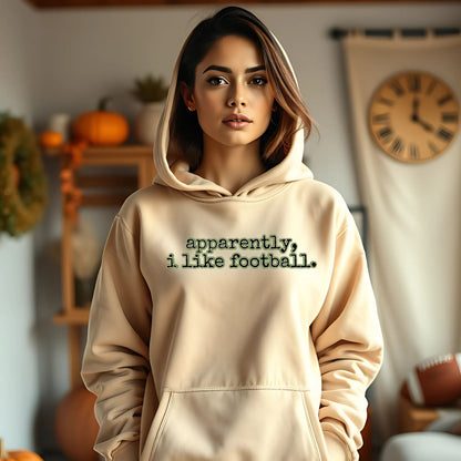 Woman wearing a beige hoodie with text in a cozy indoor setting