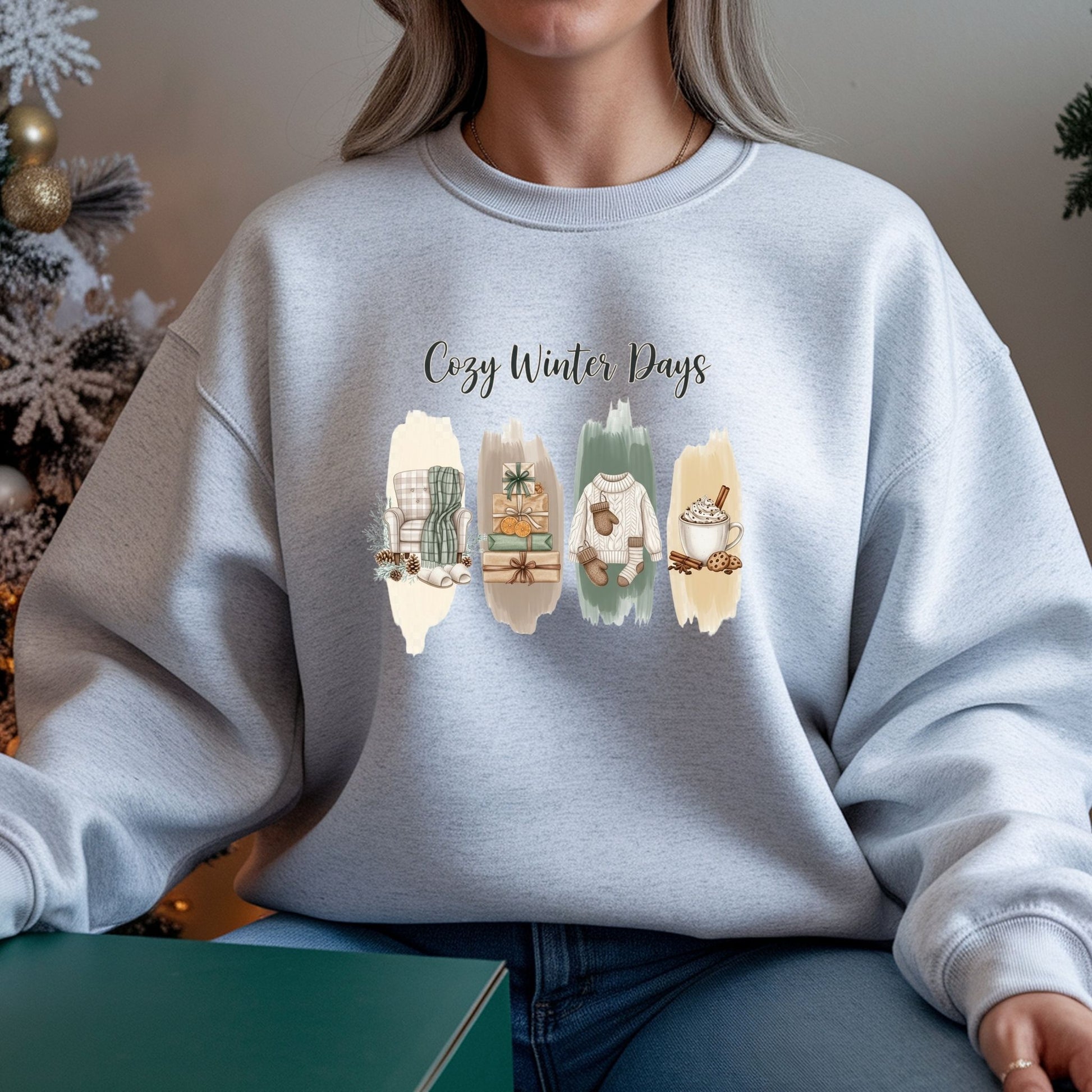 Person wearing a light gray sweatshirt with 'Cozy Winter Days' and winter-themed illustrations.