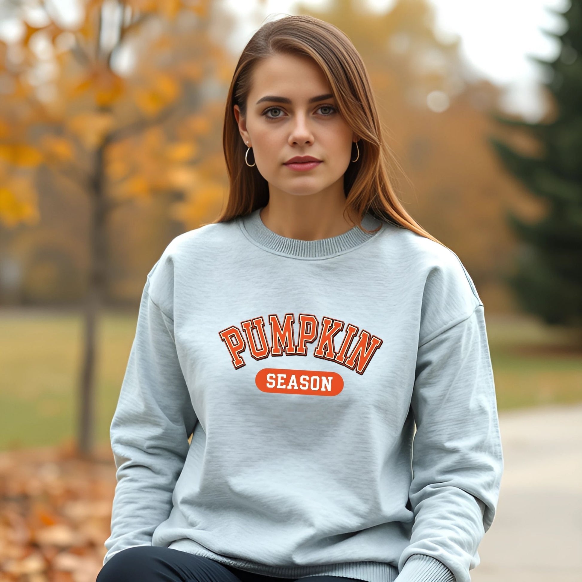 Woman wearing a gray sweatshirt with 'Pumpkin Season' text in an outdoor setting.