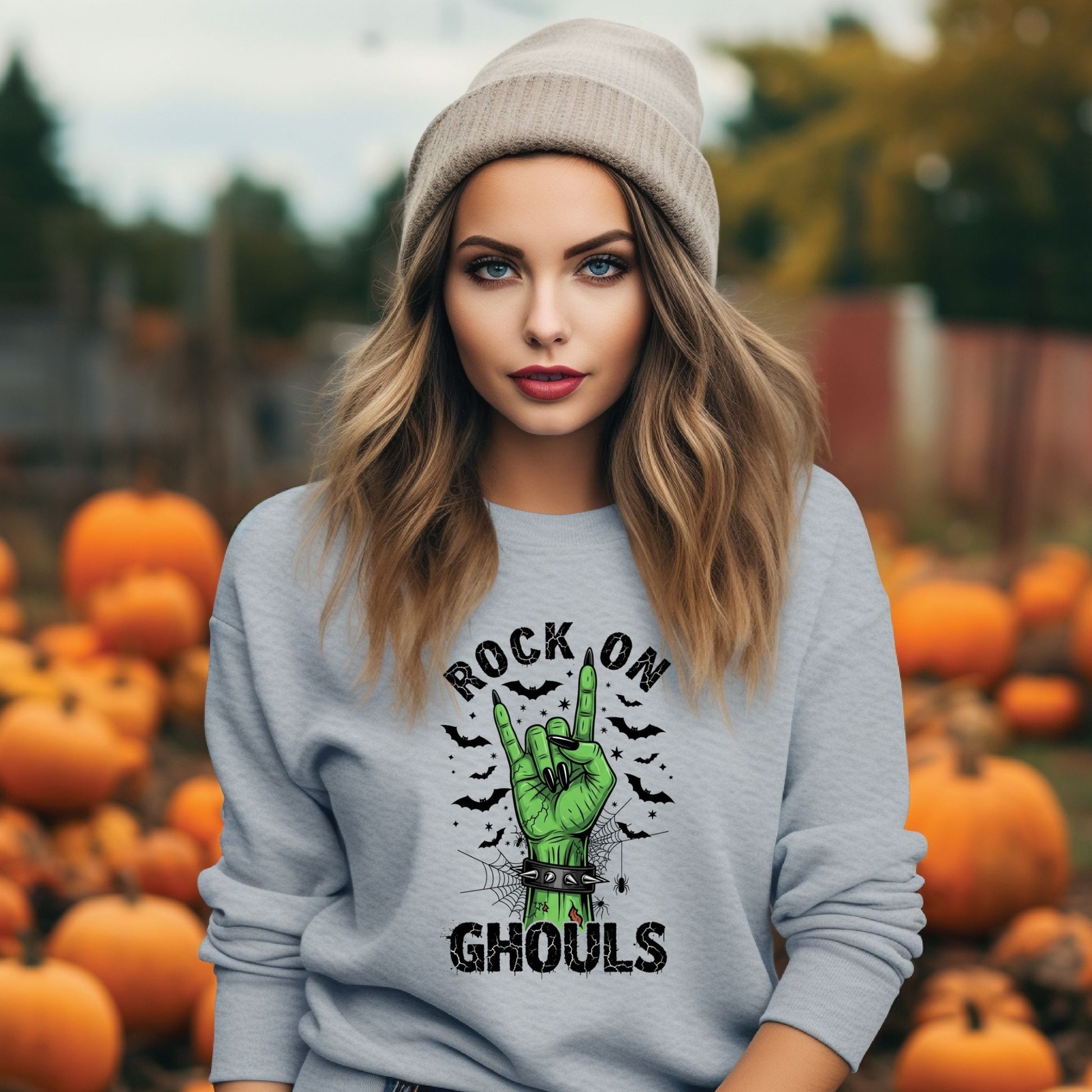 Woman wearing a sweatshirt with 'Rock on Ghouls' design in a pumpkin patch