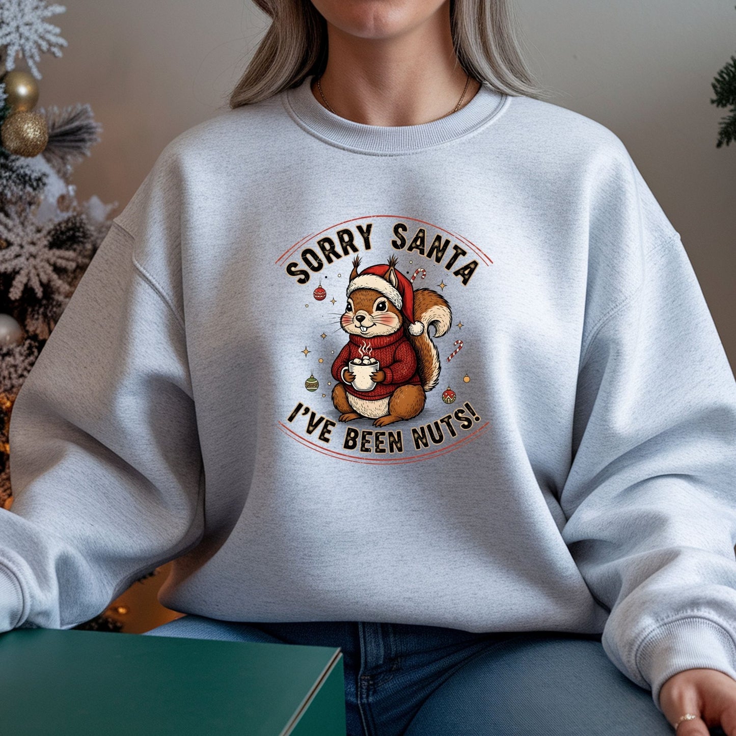 Person wearing a white sweatshirt with a Christmas-themed design featuring a squirrel and text.
