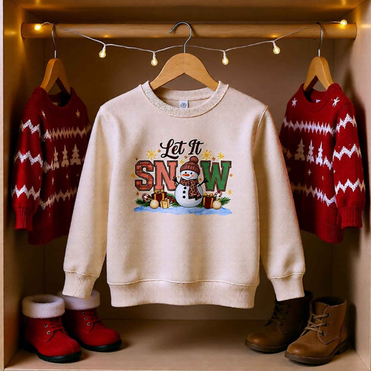 Flat lay of “Let It Snow” snowman Christmas crewneck sweatshirt displayed on a hanger with festive holiday decor.