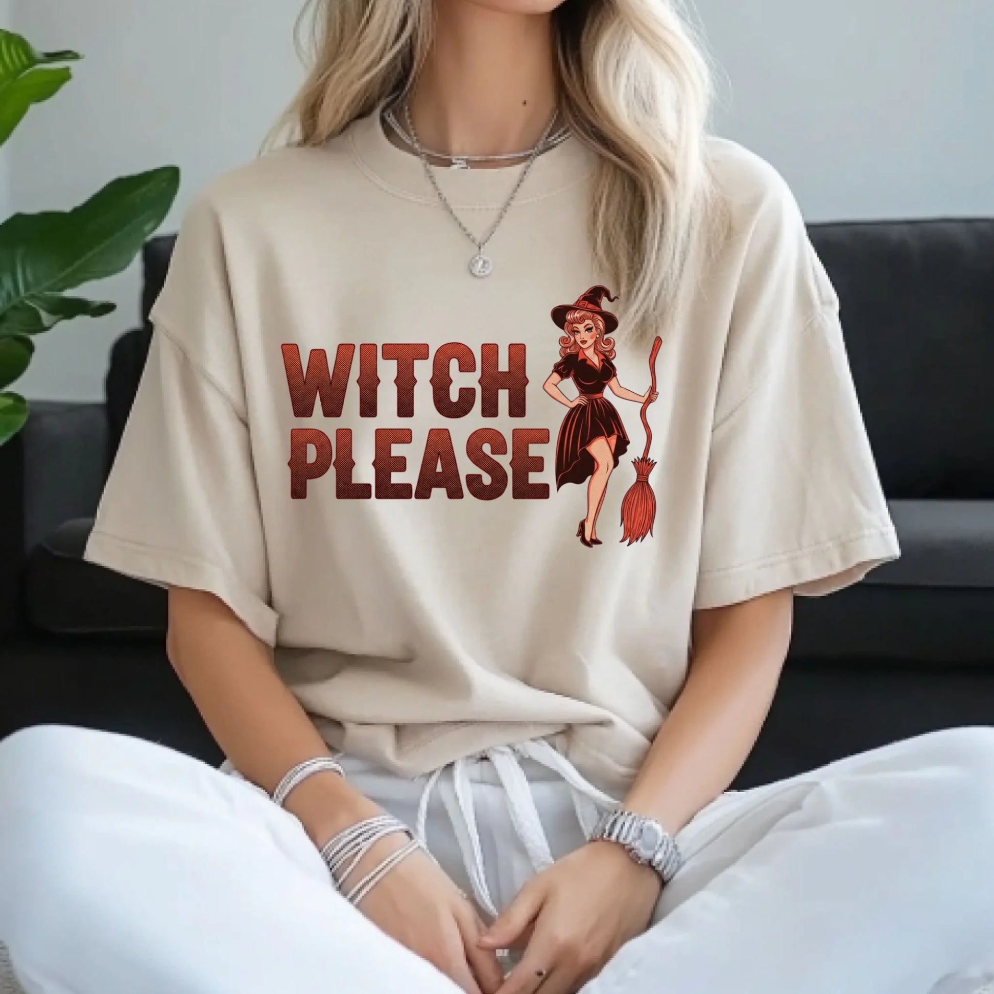 Person wearing a beige t-shirt with 'Witch Please' text and graphic