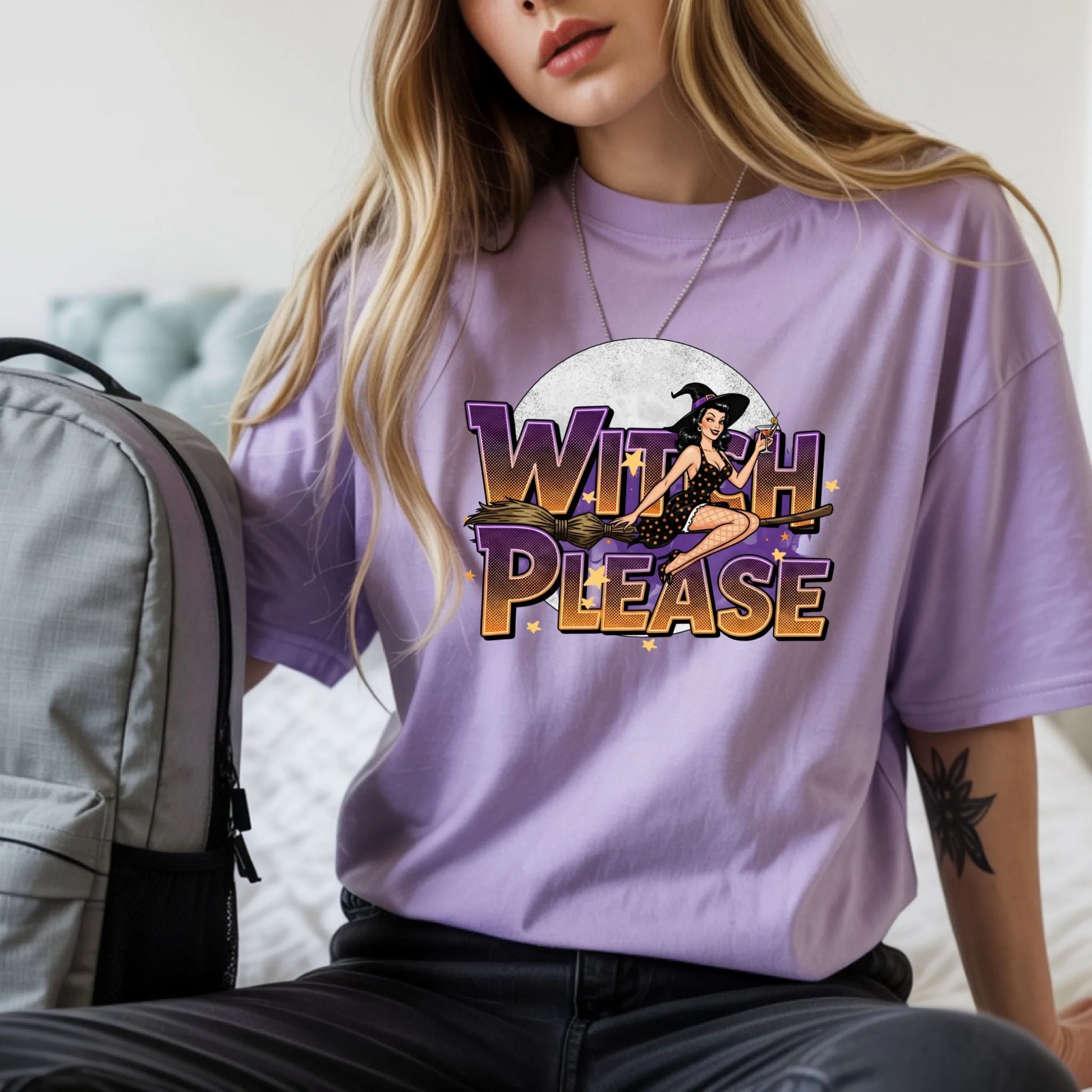 Person wearing a purple t-shirt with 'Witch Please' graphic design.