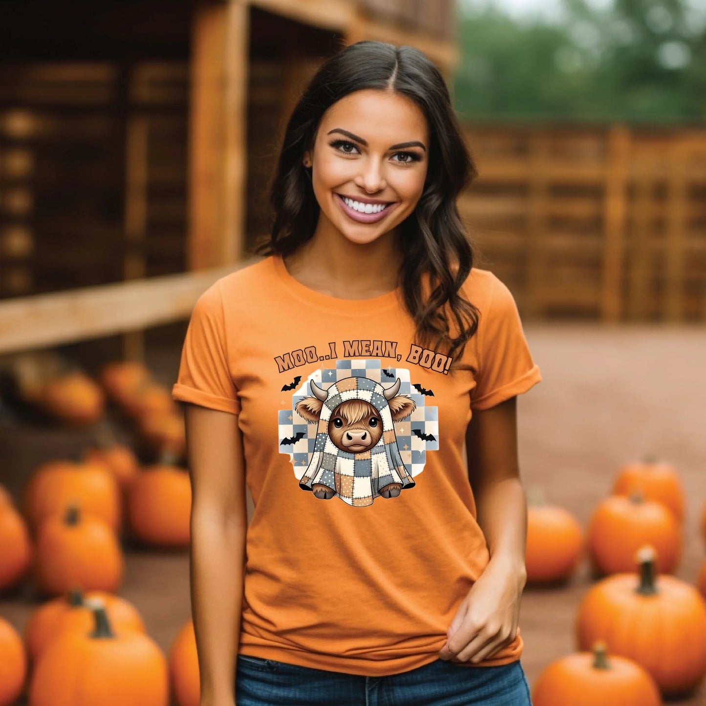 Woman wearing an orange t-shirt with a graphic design of a cow in a checkered shirt and text 'MOO.