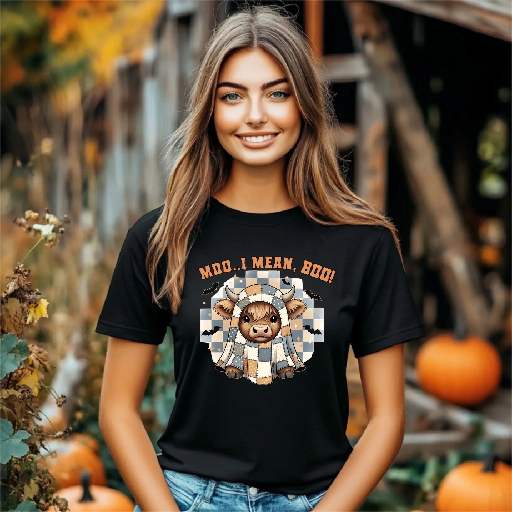 Woman wearing a black t-shirt with a cow graphic and text in an autumn setting