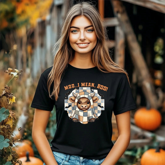 Woman wearing a black t-shirt with a cow graphic and text in an autumn setting