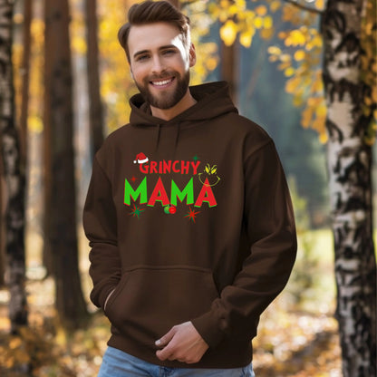 Man wearing a brown hoodie with 'Grinchy Mama' text in an autumn forest setting