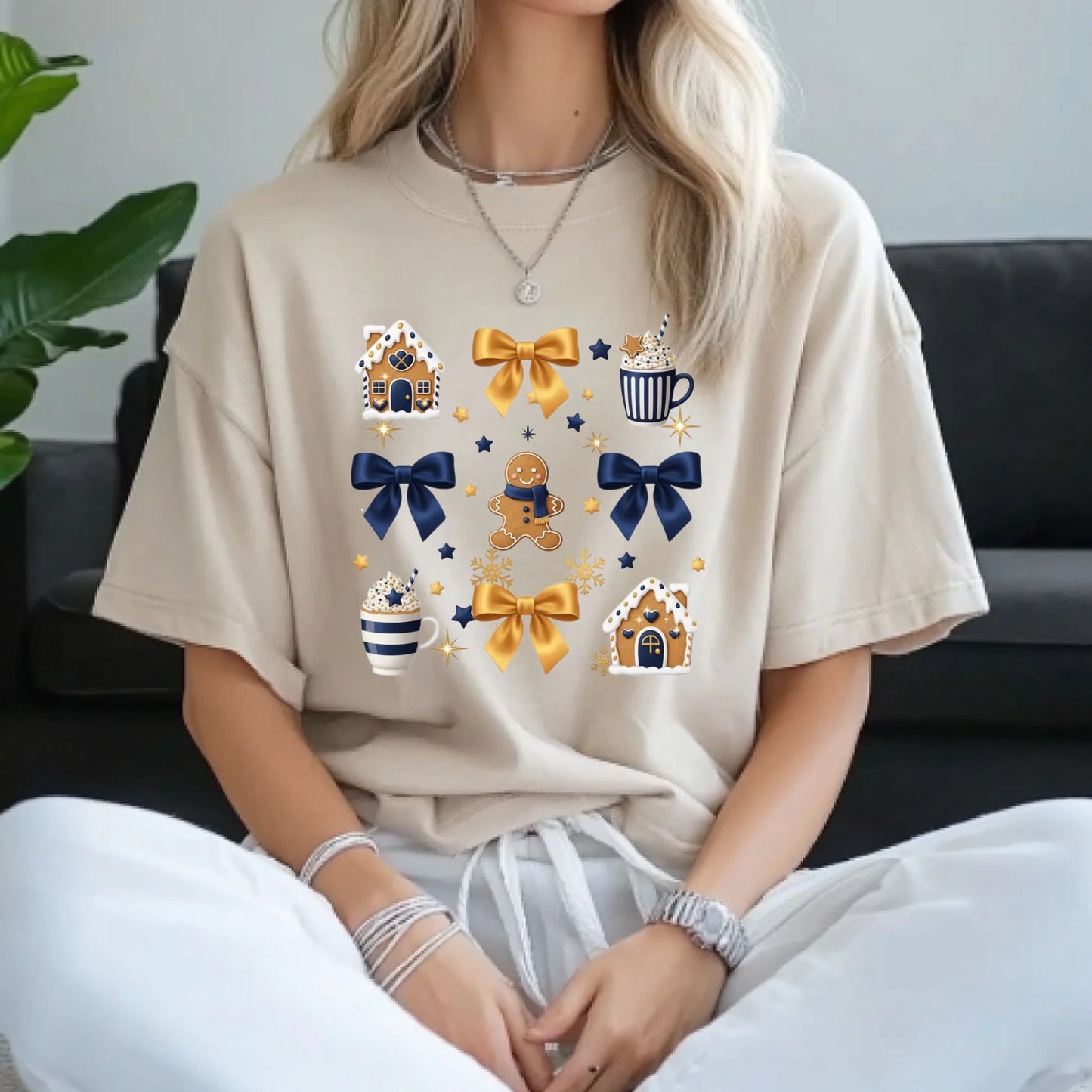 Person wearing a beige t-shirt with colorful graphics sitting on a couch.
