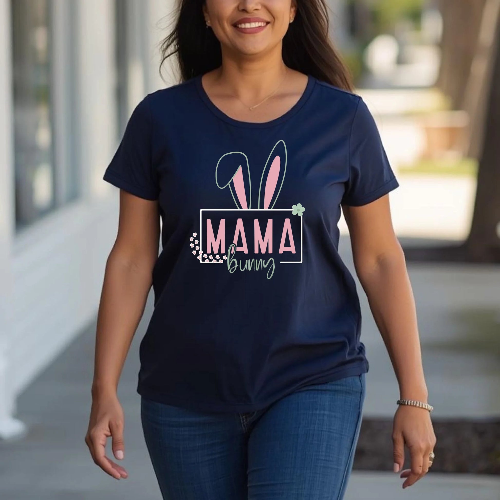 Woman wearing a navy Easter bunny mama t-shirt while walking outdoors in a natural spring setting.