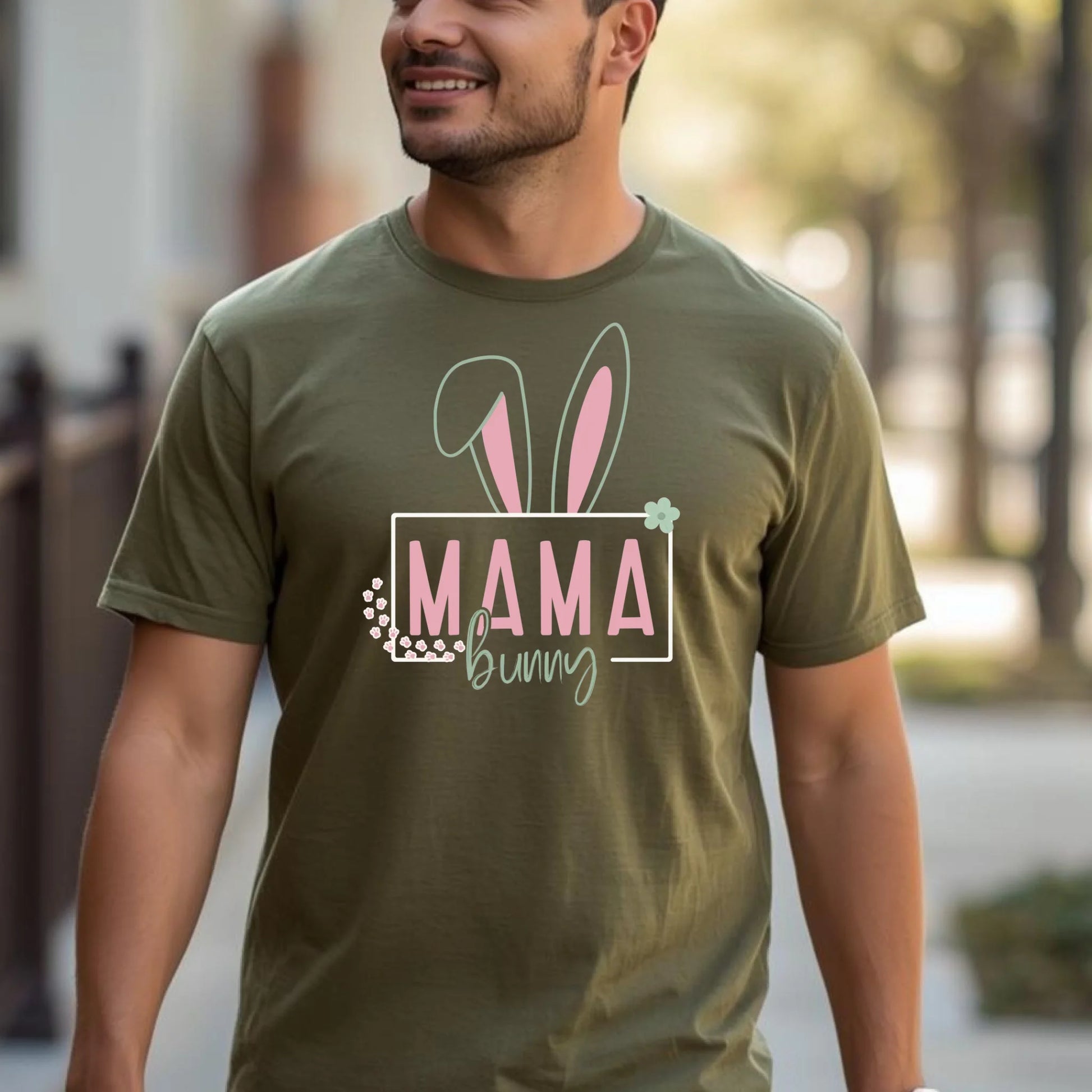 Adult wearing an olive Easter bunny family t-shirt in a casual outdoor lifestyle scene.