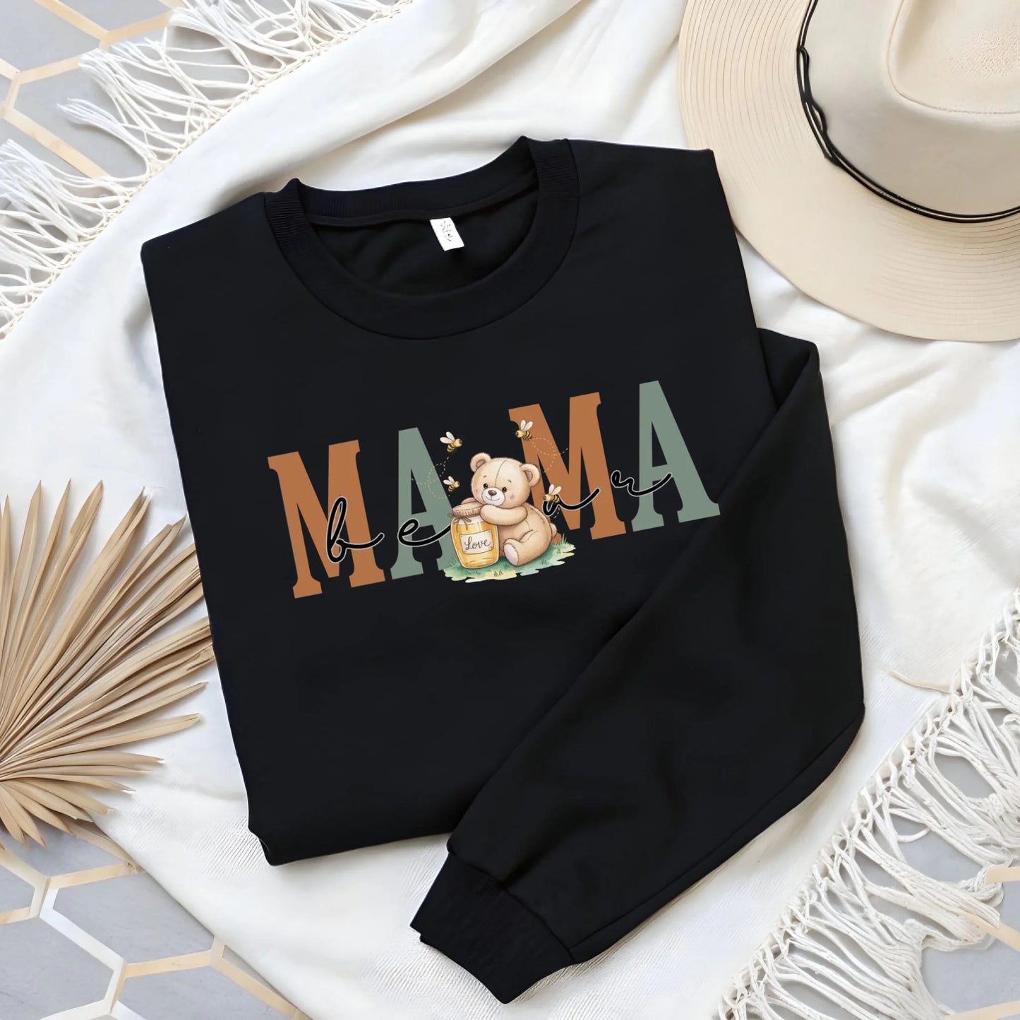 Flat lay image of a black personalized mama crewneck highlighting the honey bear artwork and premium print quality.
