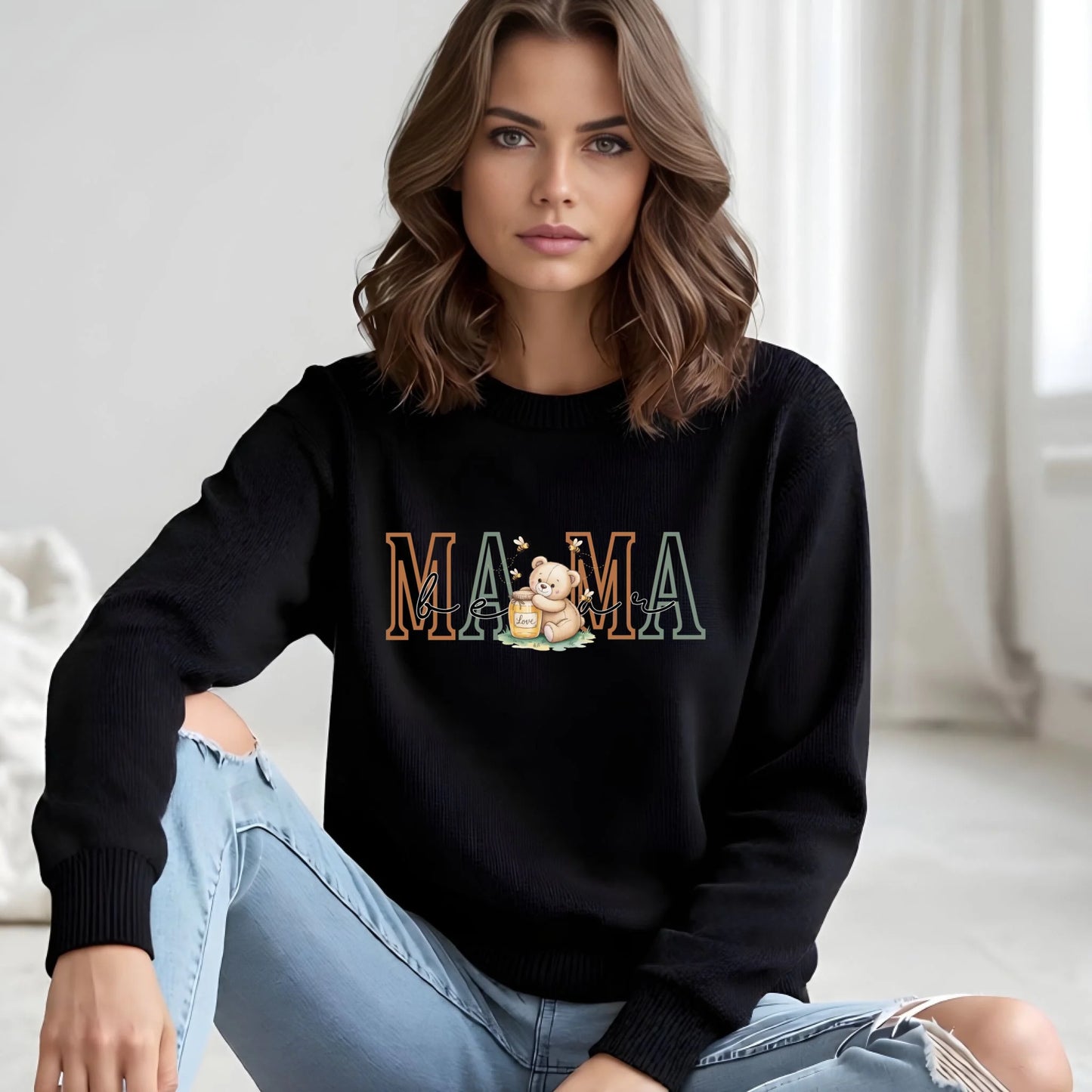 Model wearing a black personalized Mama crewneck sweatshirt featuring the teddy bear family role artwork, styled for a clean and modern look.