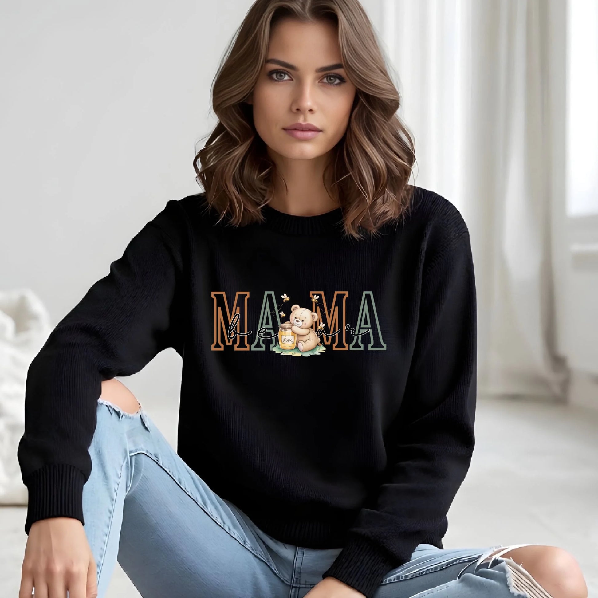 Model wearing a black personalized Mama crewneck sweatshirt featuring the teddy bear family role artwork, styled for a clean and modern look.