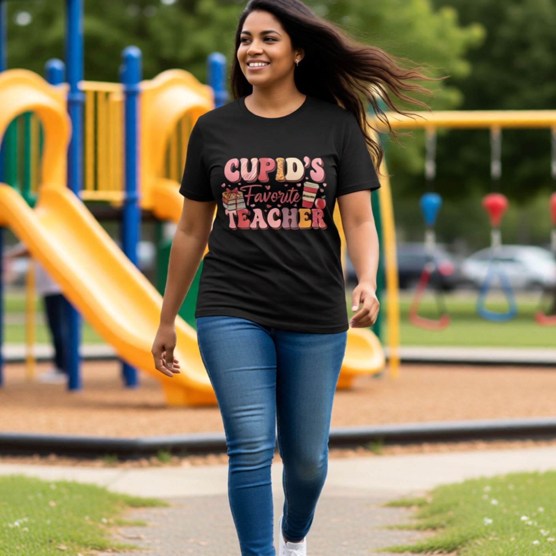 Teacher walking confidently at a playground wearing a black Cupid’s Favorite Teacher graphic t-shirt with colorful Valentine lettering.