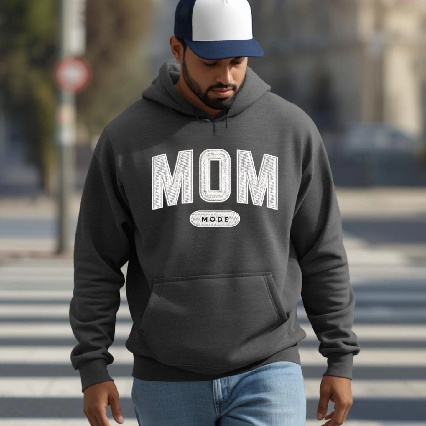 Man wearing a gray hoodie with 'DAD MODE' text on a blurred street background