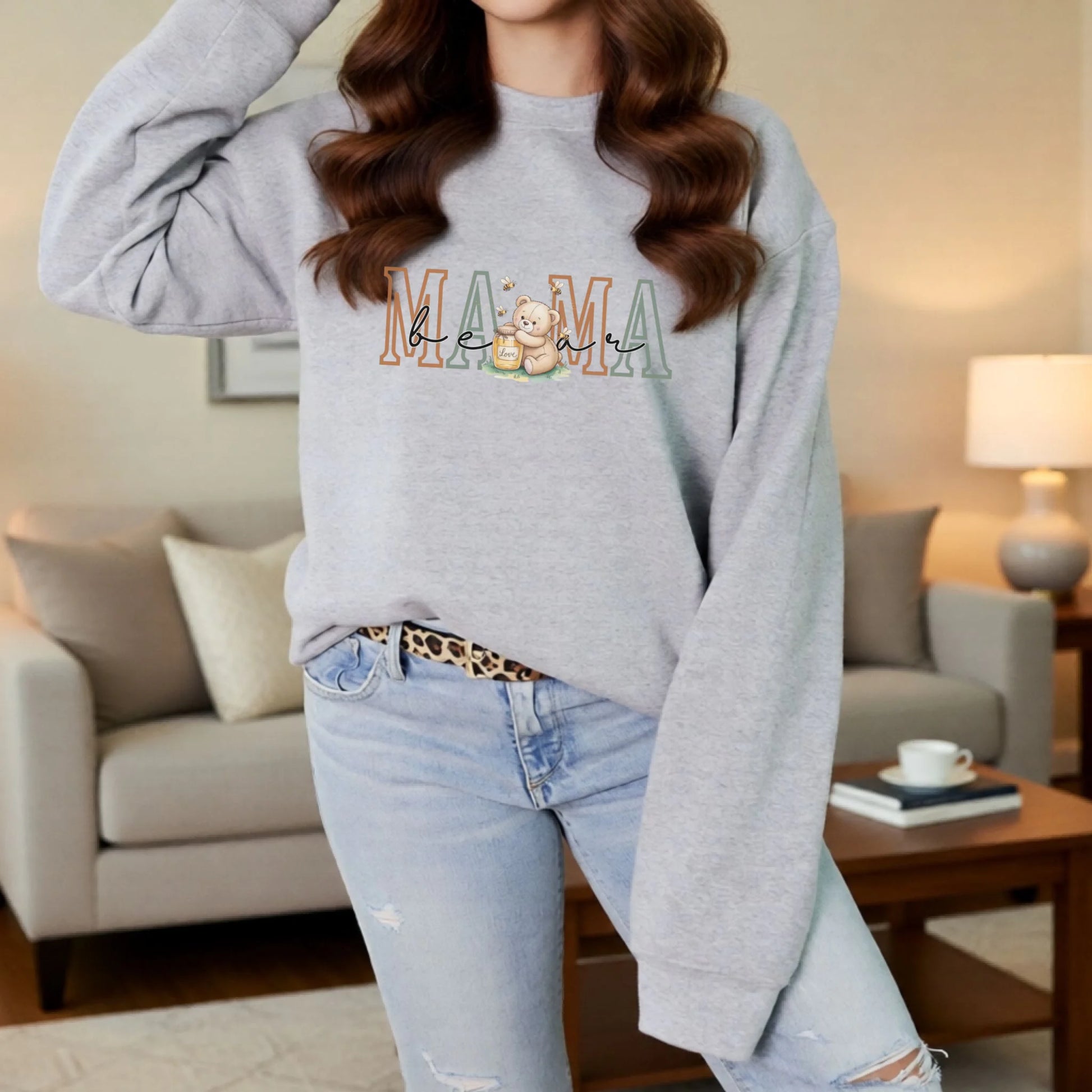Casual lifestyle mockup of a gray personalized Mama crewneck sweatshirt with the teddy bear family role design on the front.