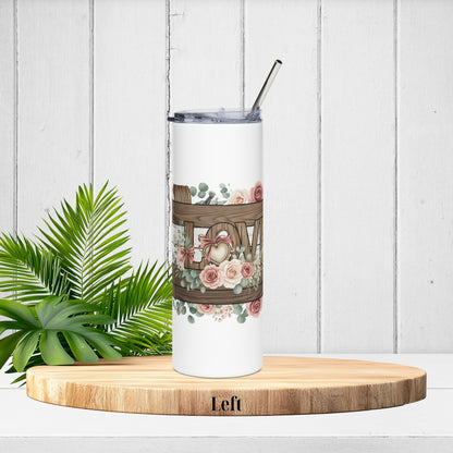 Left-side tumbler angle showing the start of the LOVE letters with twine, florals, and soft pink roses on distressed wood.
