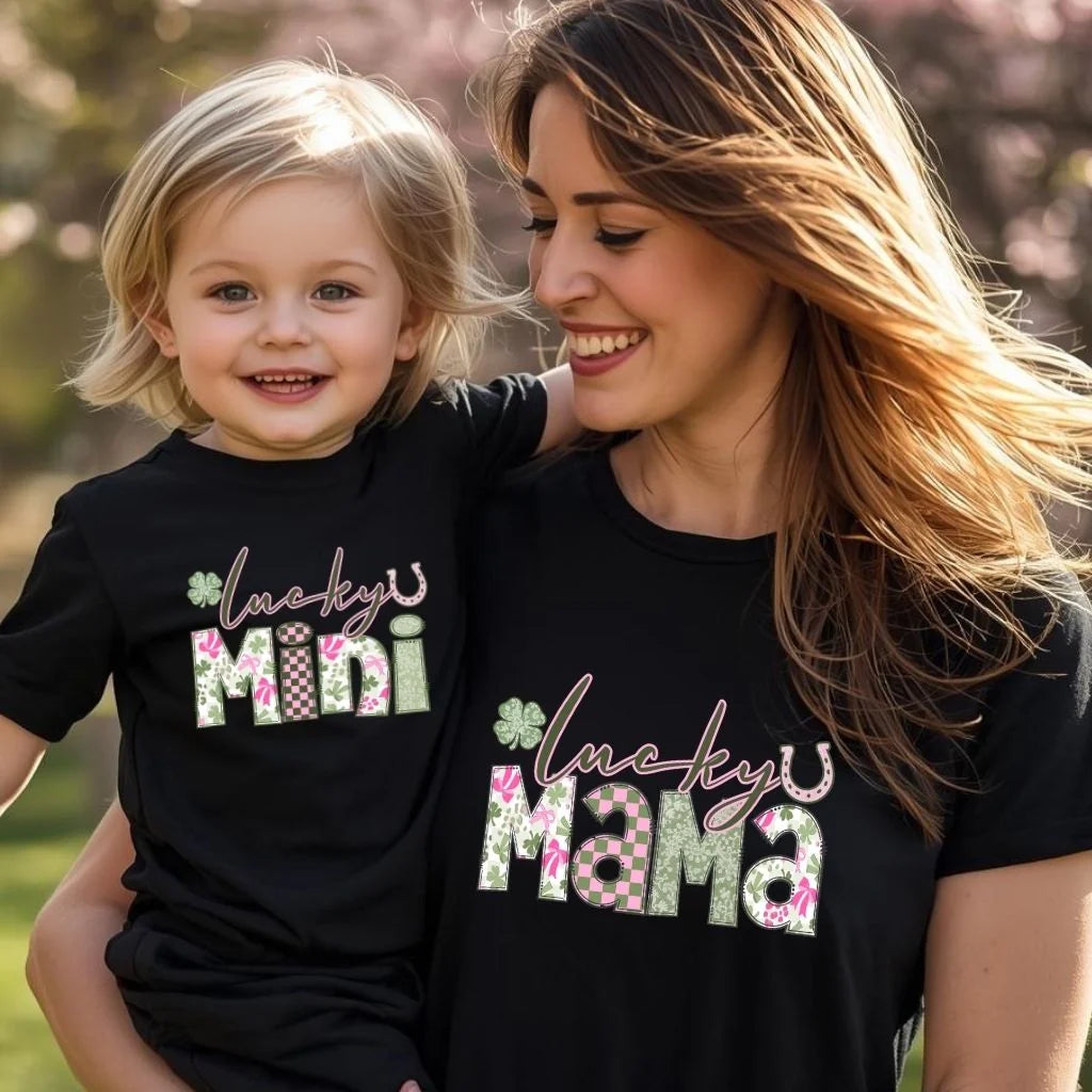 Woman and child wearing matching black t-shirts with 'lucky mini' and 'lucky mama' text.