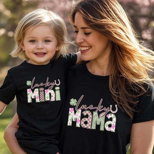 Woman and child wearing matching black t-shirts with 'lucky mini' and 'lucky mama' text.