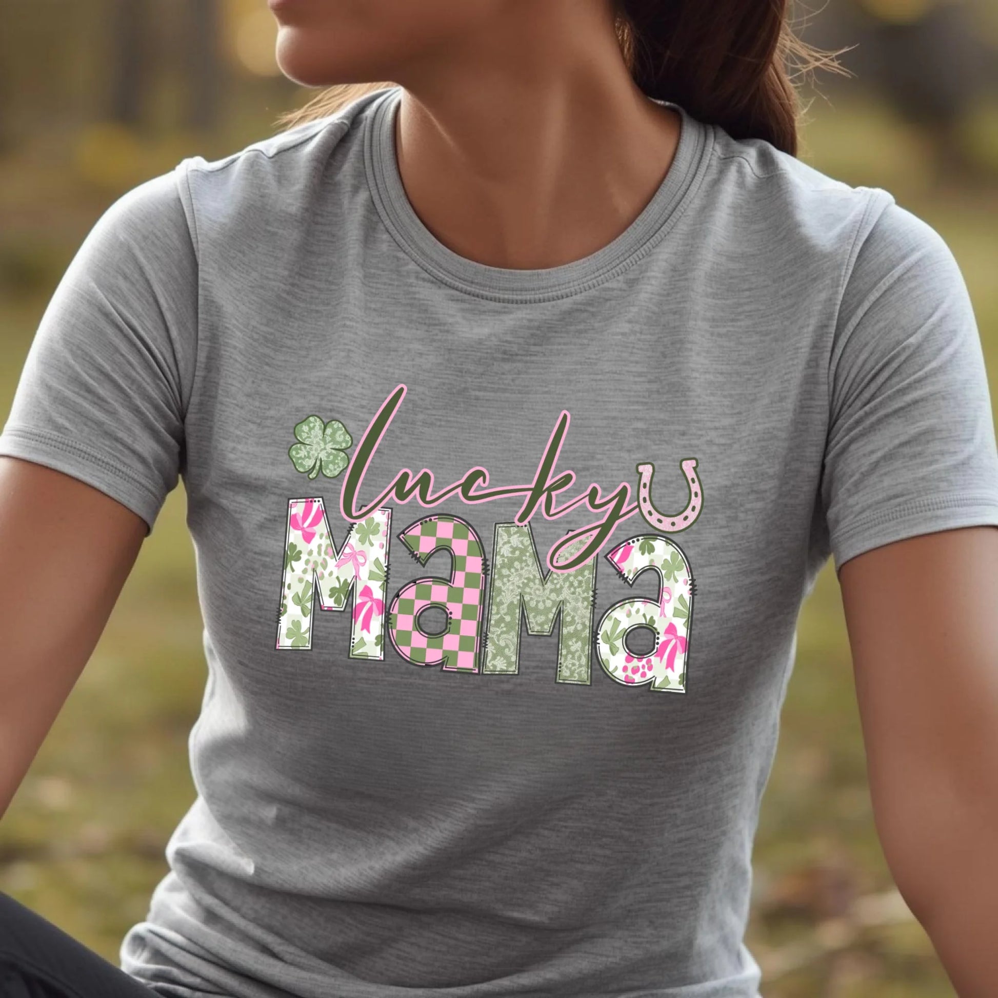Person wearing a gray t-shirt with 'lucky mama' design outdoors