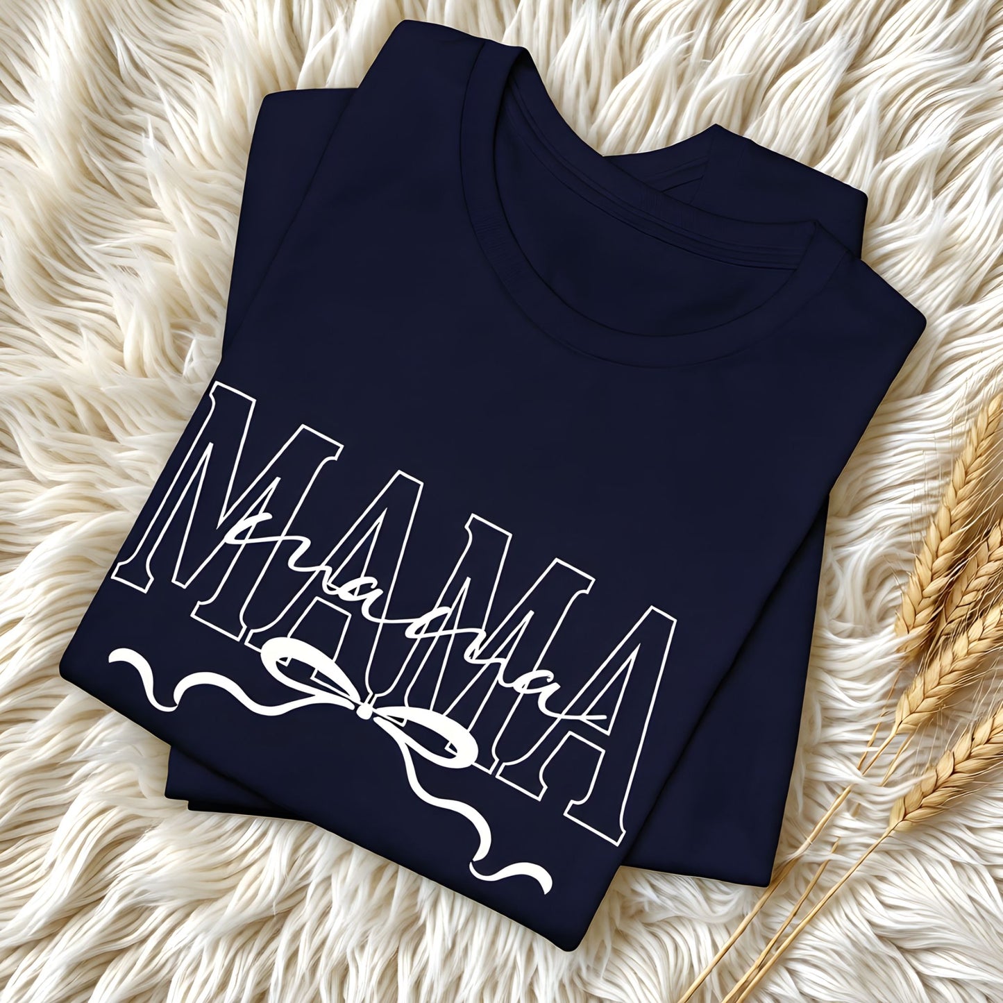 Folded dark-color Mama t-shirts featuring a white script and bow design, displayed in a clean flat lay.