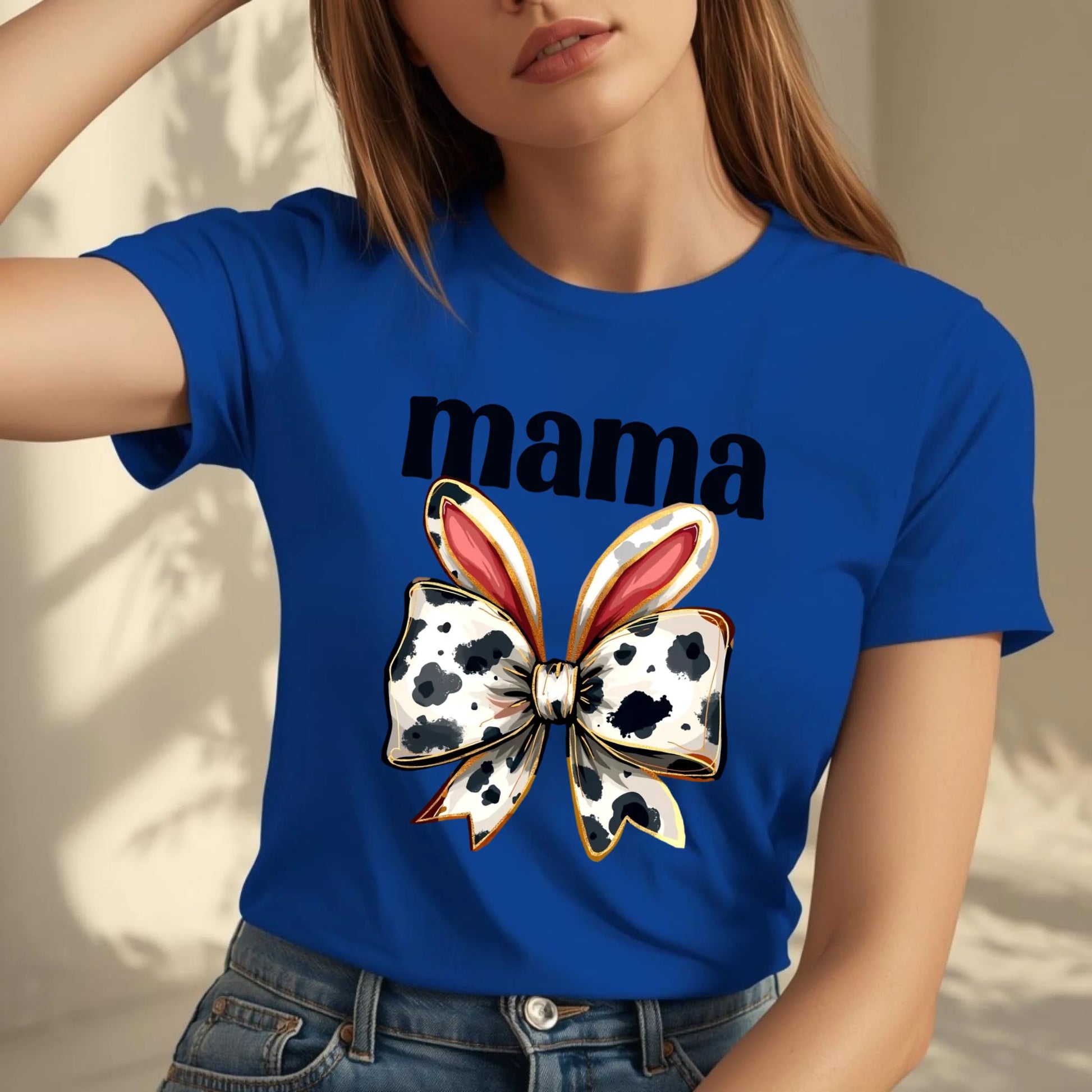 Torso-only lifestyle photo of a woman wearing a blue Bella + Canvas mama t-shirt with a cow print bunny bow design, natural movement and soft lighting.