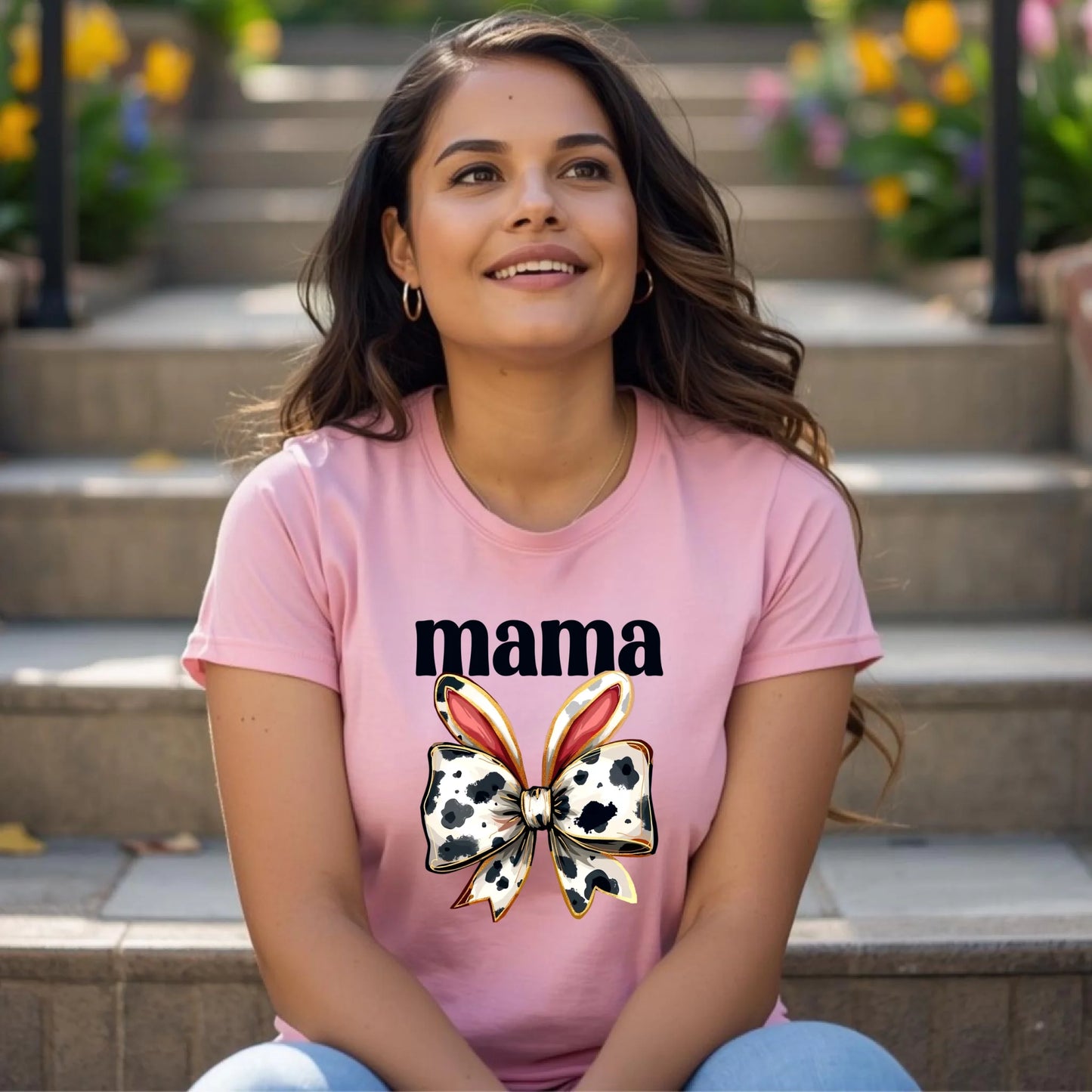 Woman wearing a pink Bella + Canvas t-shirt featuring a cow print bunny bow mama design, styled for a spring Mother’s Day outfit in an outdoor lifestyle setting.