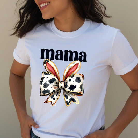 Close-up lifestyle photo of a woman wearing a white Bella + Canvas mama t-shirt with a cow print bunny bow graphic, casual spring fashion look.