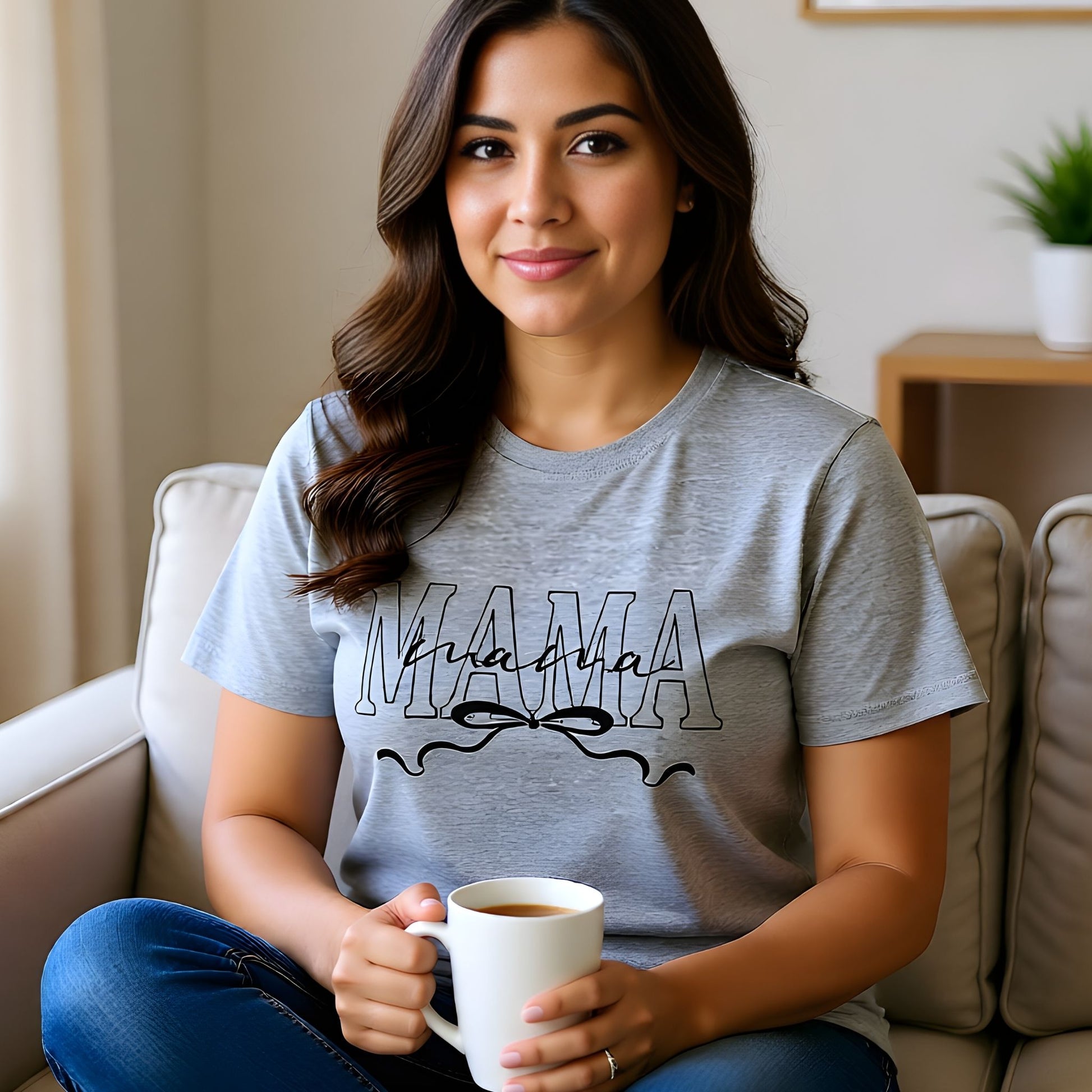 Woman wearing a heather gray Mama bow script t-shirt while holding a coffee, perfect for relaxed mom outfits.