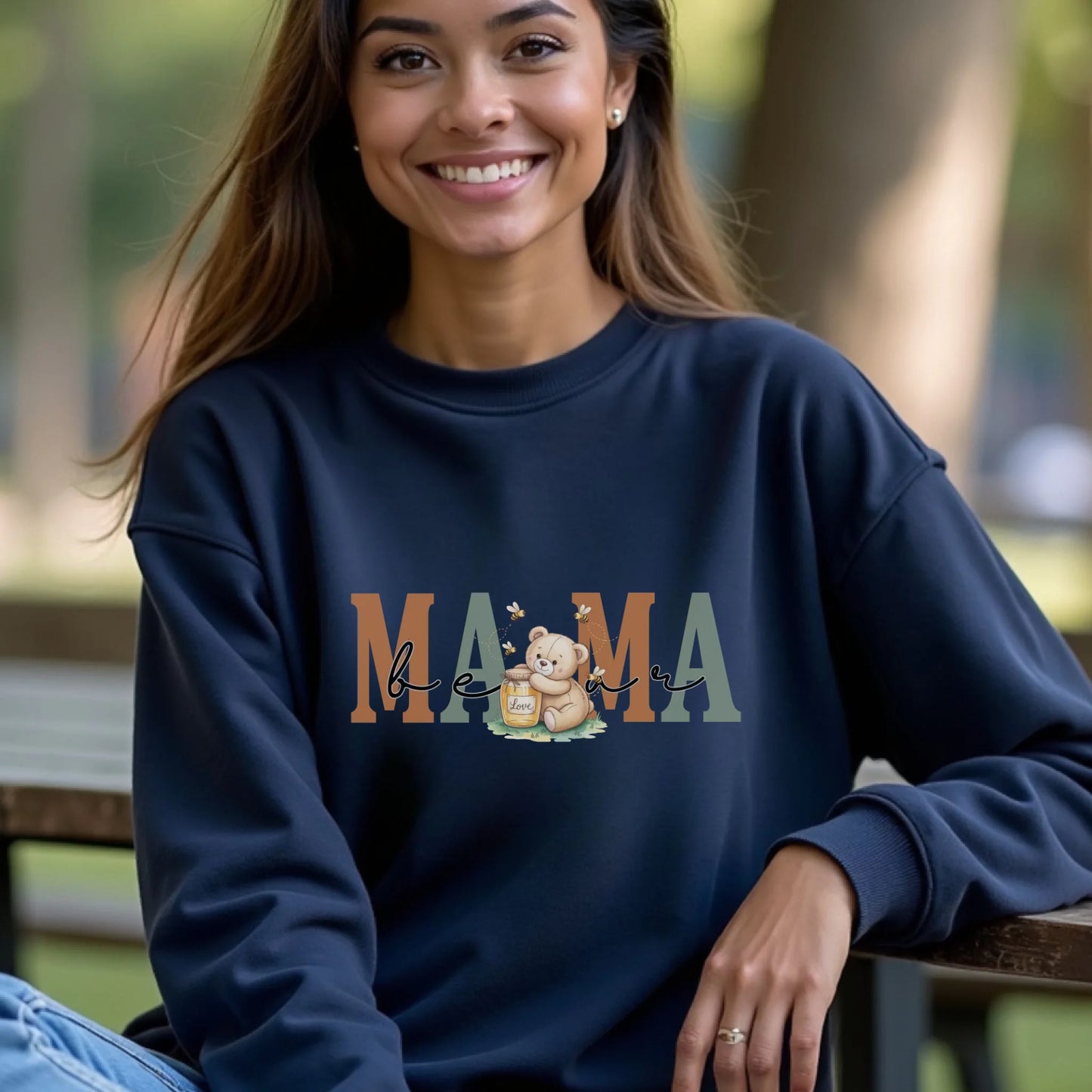 Smiling woman wearing a navy Gildan crewneck with the mama honey bear family role design in a casual outdoor setting.