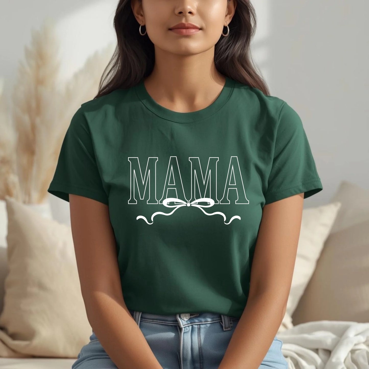 Person wearing a green t-shirt with 'MAMA' printed on it, sitting in a cozy indoor setting.