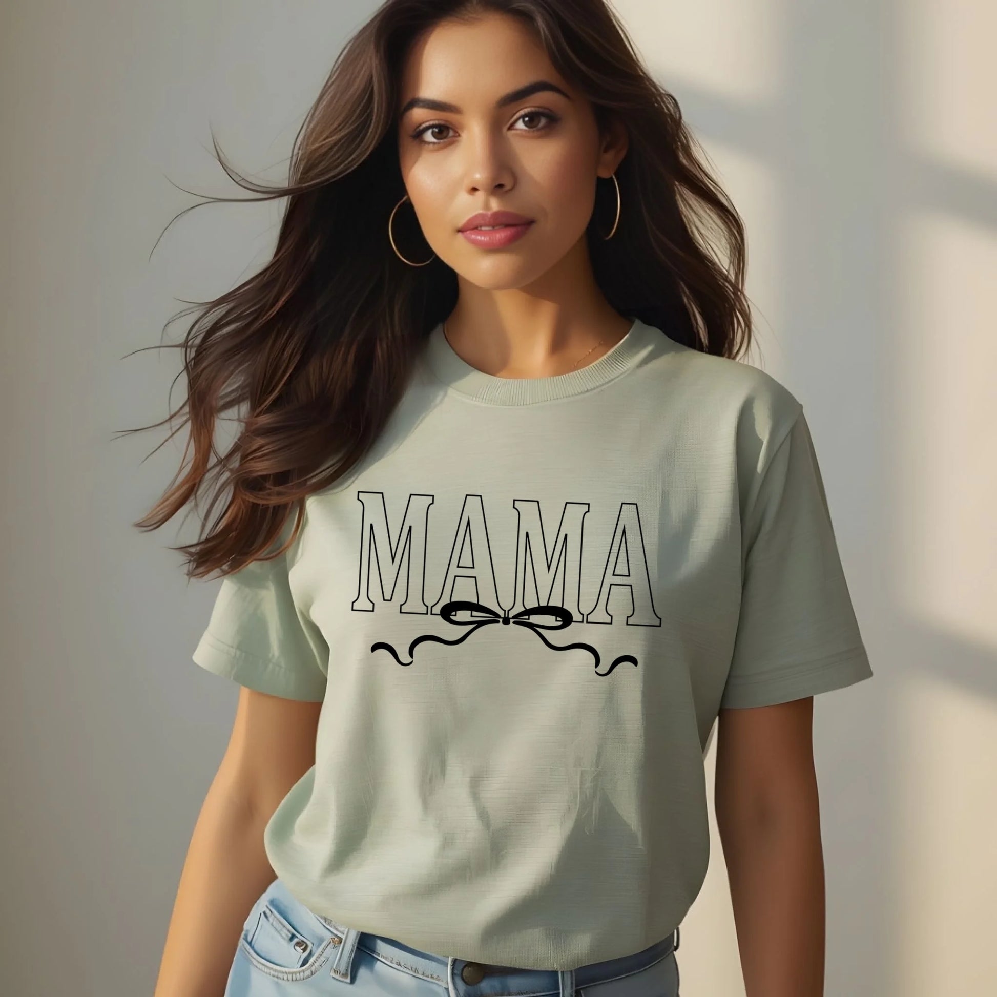 Woman wearing a light green t-shirt with 'MAMA' printed on it against a neutral background